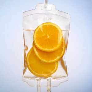 A medical IV bag filled with liquid and slices of fresh oranges, symbolizing High-Dose IV Vitamin C therapy.