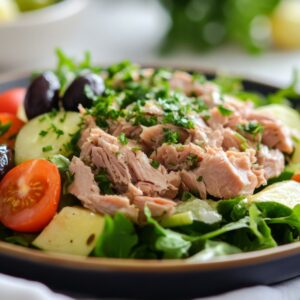 A vibrant spring salad with mixed greens, cherry tomatoes, avocado, Kalamata olives, feta cheese, and a drizzle of lemon-herb vinaigrette.