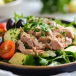 A vibrant spring salad with mixed greens, cherry tomatoes, avocado, Kalamata olives, feta cheese, and a drizzle of lemon-herb vinaigrette.